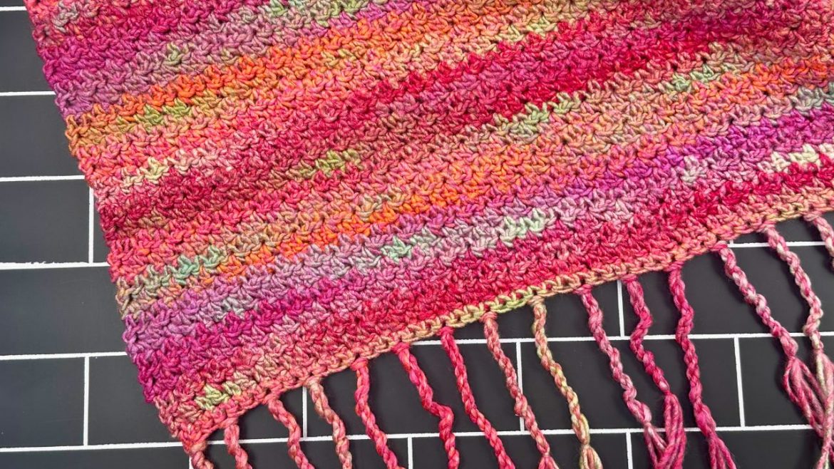 FInished twisted fringe on a colorful camfire scarf with a black background